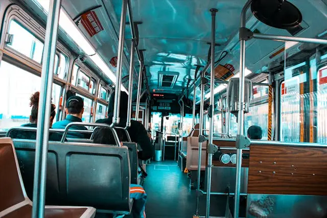 Interior of a public bus with passengers seated and standing