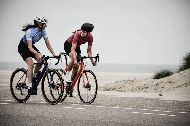 Two cyclists riding on a beachside road in Hawaiʻi