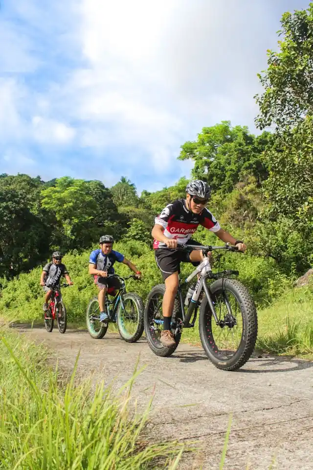 Group of cyclists riding together on a trail surrounded by greenery