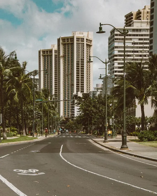 Bike lane on a city street in Honolulu, Hawaii with palm trees and high-rise buildings in Waikiki