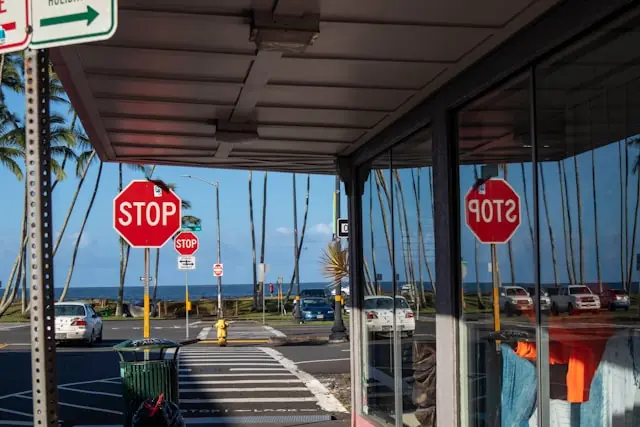 Intersection with stop signs and crosswalk in Honolulu near the ocean