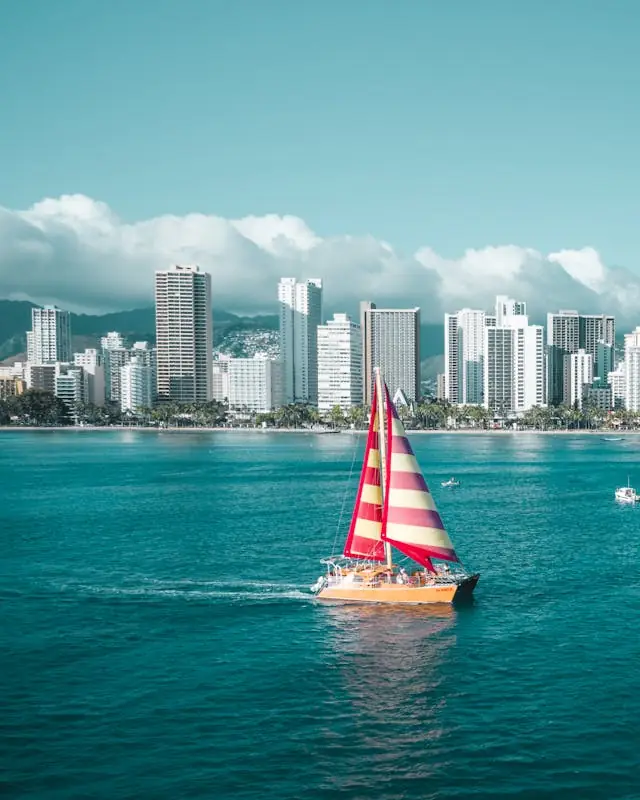 Sailboat on the ocean in Waikīkī with the Honolulu skyline in the background