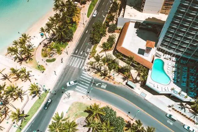 Aerial view of a Waikīkī intersection with crosswalks and traffic near the beach