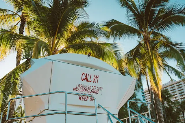 Beach lifeguard tower with warning sign indicating no lifeguard on duty in Hawaii